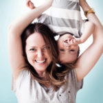 Young woman holding baby boy (6-11 months) upside-down